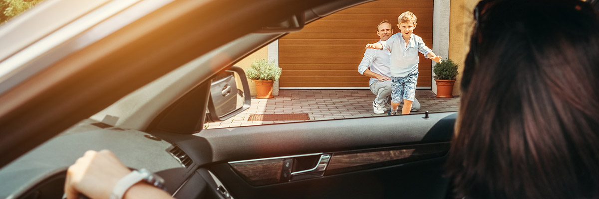 Mother in car while happy son runs to her with father behind him